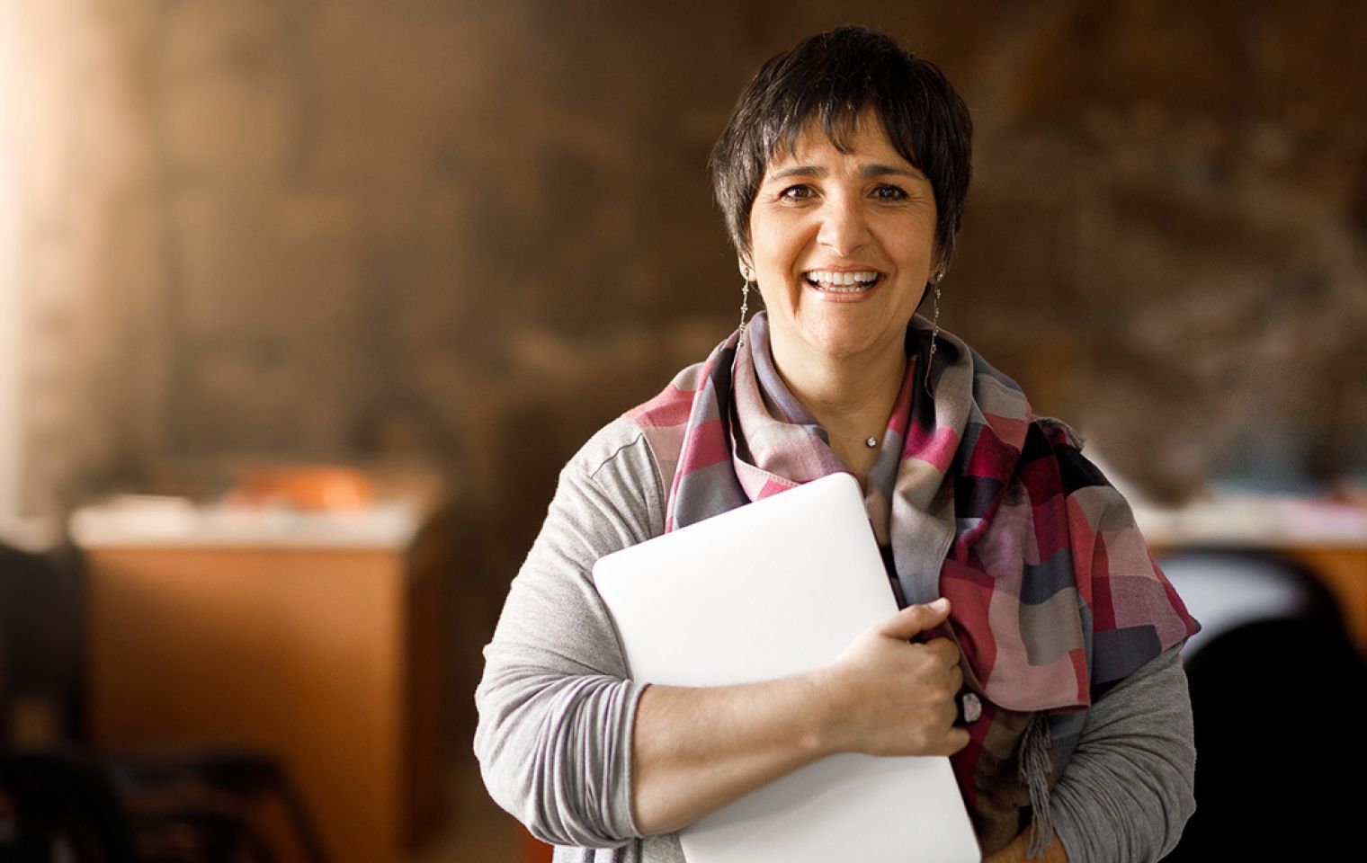 Woman with menopause at work holding a laptop